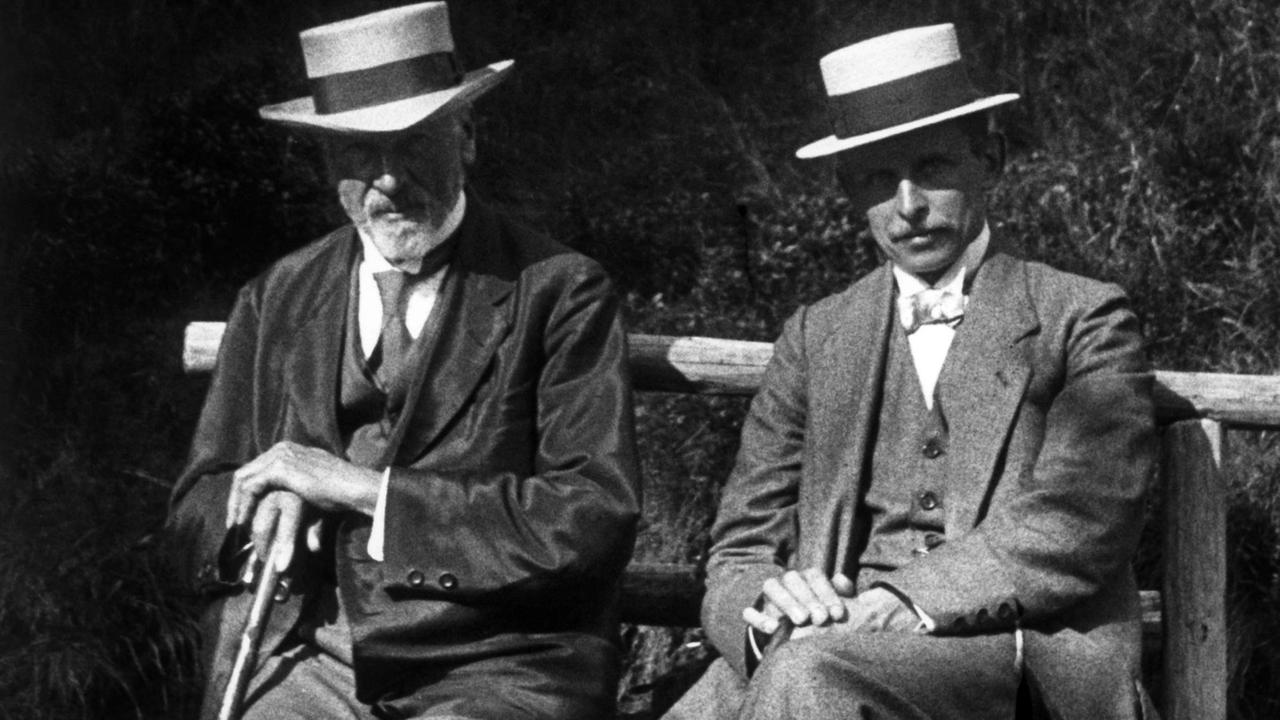 Ernst Leitz der Ältere, Gründer des "Optischen Instituts", und sein Werkmeister Oskar Barnack sitzen in Hut und Anzug auf einer Bank.