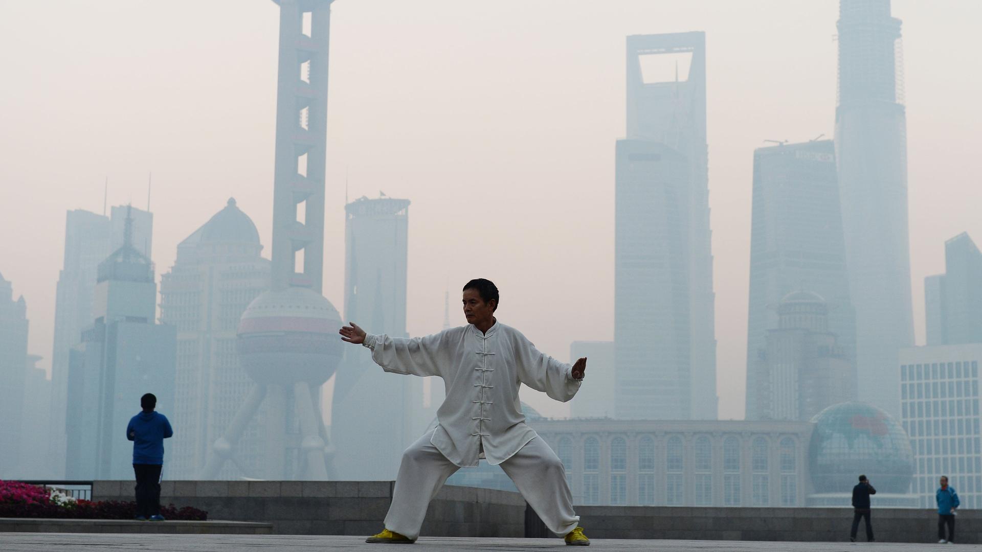 Ein Chinese übt Tai Chi in Shanghai, wo Smog herrscht Ein Chinese übt Tai Chi in Shanghai, wo Smog herrscht