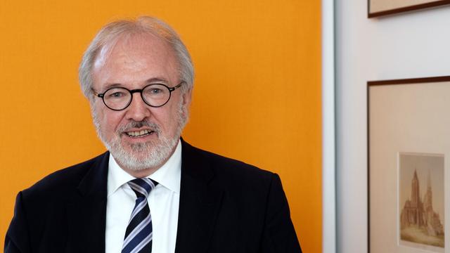 Der Vorsitzende des Marburger Bundes Rudolf Henke trägt schwarzen Anzug und gestreifte Krawatte.