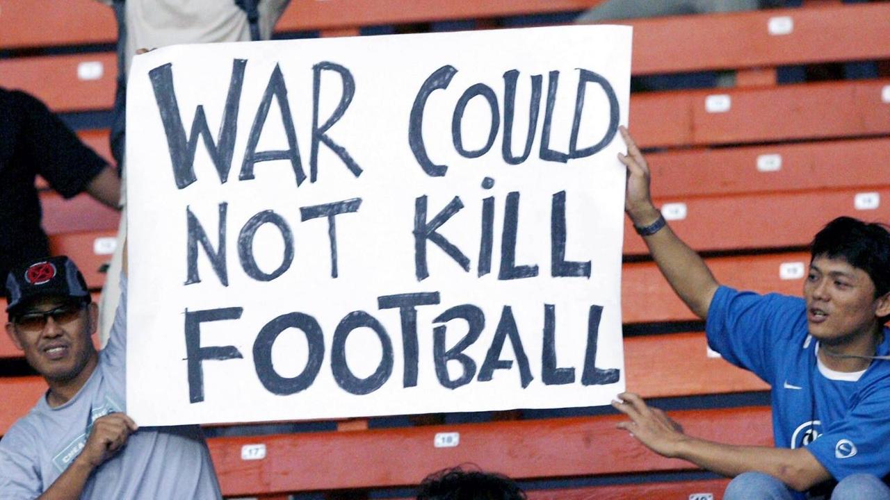 Irakische Fans freuen sich mit einem Schild auf dem steht "War Could Not Kill Football" über den Erfolg ihrer Mannschaft trotz der Kriegssituation in der Heimat während des Asiencups 2007.