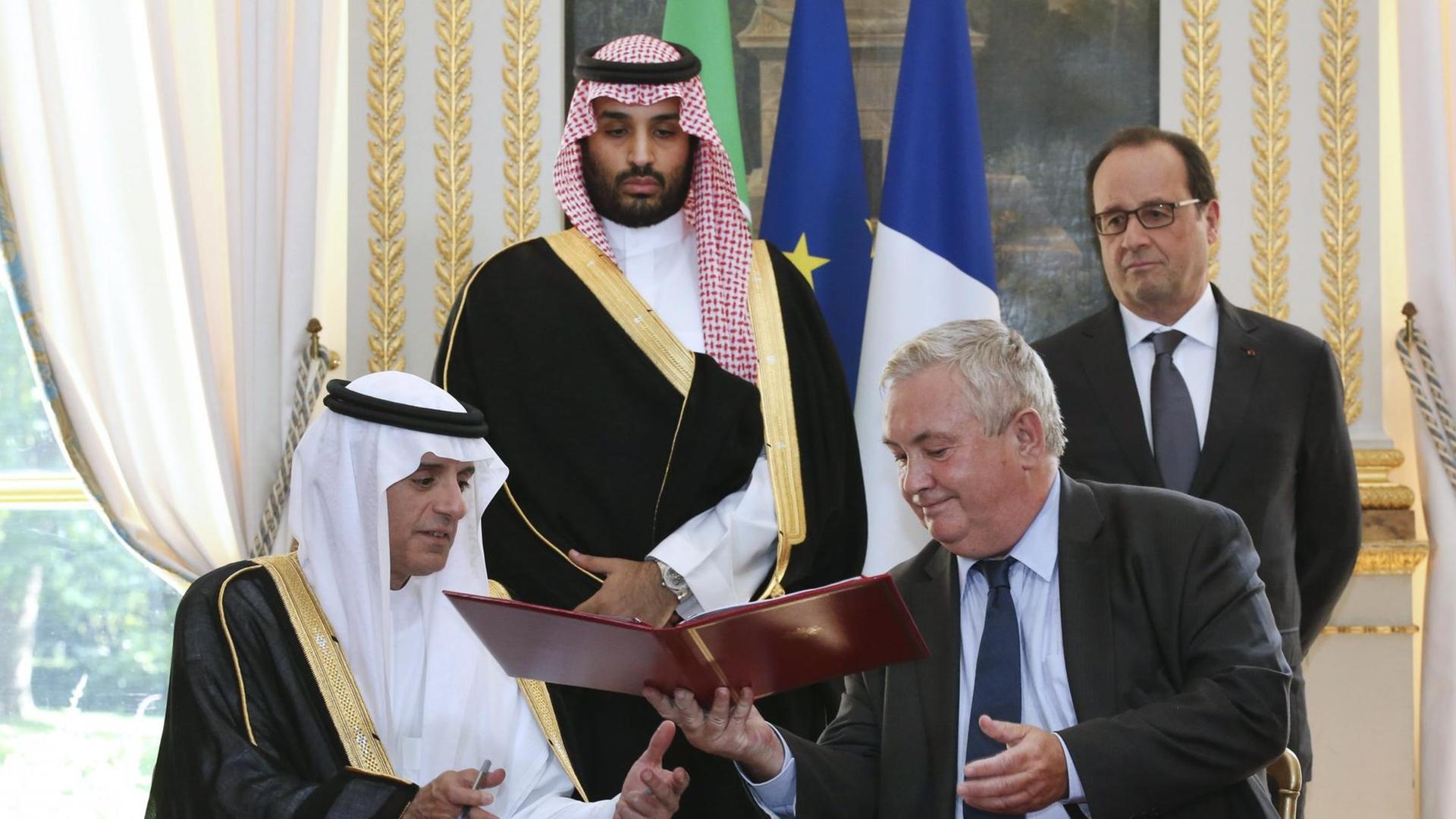 Eurocopter Senior Vice President für Vertrieb und Kundenbeziehungen Olivier Lambert (r.) tauscht Dokumente mit der saudische Außenminister Adel al-Jubeir zur Vereinbarung über den Verkauf von 23 Helikoptern nach Saudi-Arabien aus. Im Hintergrund der französische Präsident Francois Hollande (r.) . Eurocopter Senior Vice President für Vertrieb und Kundenbeziehungen Olivier Lambert (r.) tauscht Dokumente mit der saudische Außenminister Adel al-Jubeir zur Vereinbarung über den Verkauf von 23 Helikoptern nach Saudi-Arabien aus. Im Hintergrund der französische Präsident Francois Hollande (r.) .