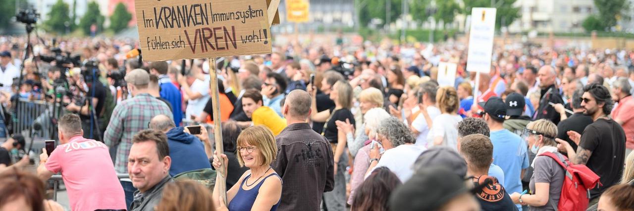 Eine Frau hält während einer Protestkundgebung ein Schild mit der Aufschrift "Viren bringen keine Krankheit! Im kranken Immunsystem fühlen sich Viren wohl!" Eine Frau hält während einer Protestkundgebung ein Schild mit der Aufschrift "Viren bringen keine Krankheit! Im kranken Immunsystem fühlen sich Viren wohl!"