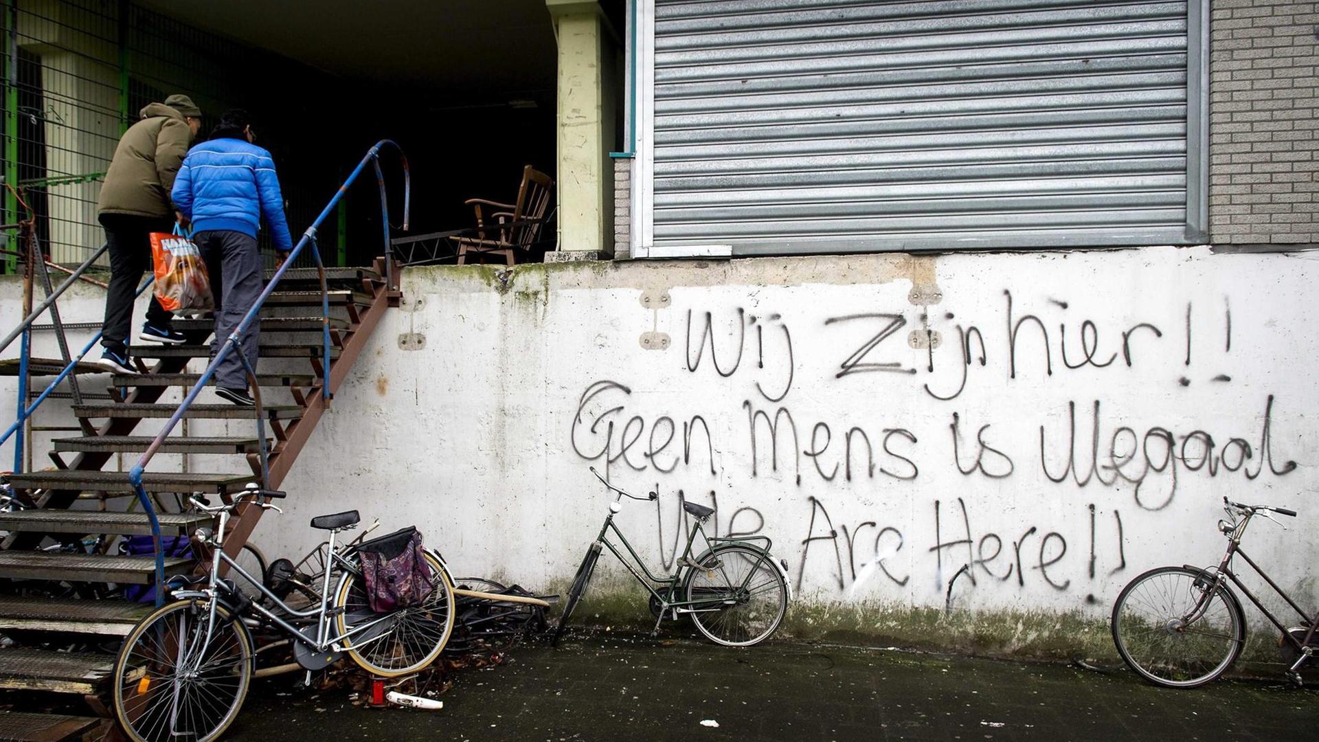 "Wir sind hier. Kein Mensch ist illegal". Schriftzug auf einem Gebäude, in dem Asylsuchende in Amsterdam leben.