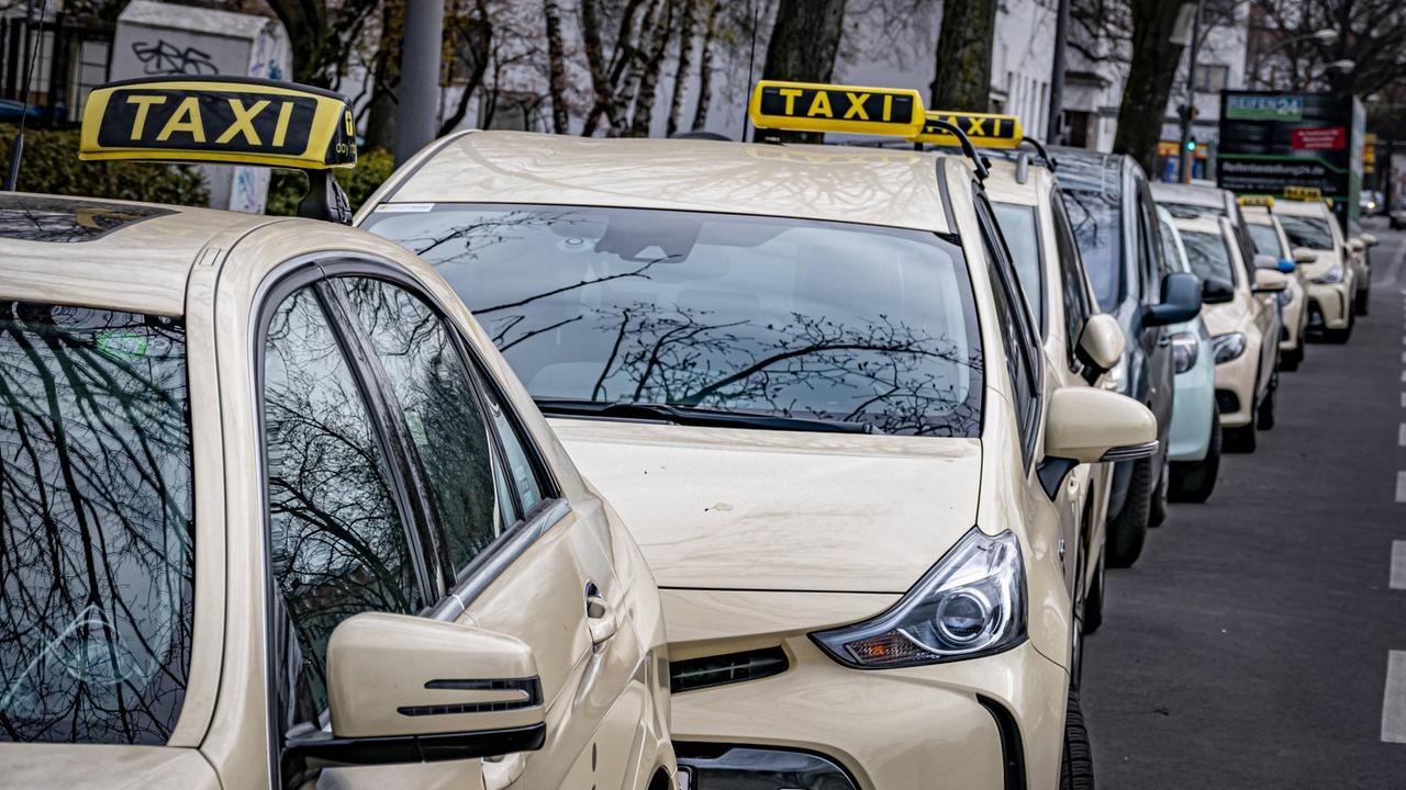 In einer langen Reihe parken Taxis am Straßenrand. In einer langen Reihe parken Taxis am Straßenrand.