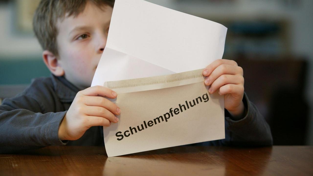 Junge (9 Jahre ) liest einen Brief mit der Aufschrift " Schulempfehlung " Junge (9 Jahre ) liest einen Brief mit der Aufschrift " Schulempfehlung "