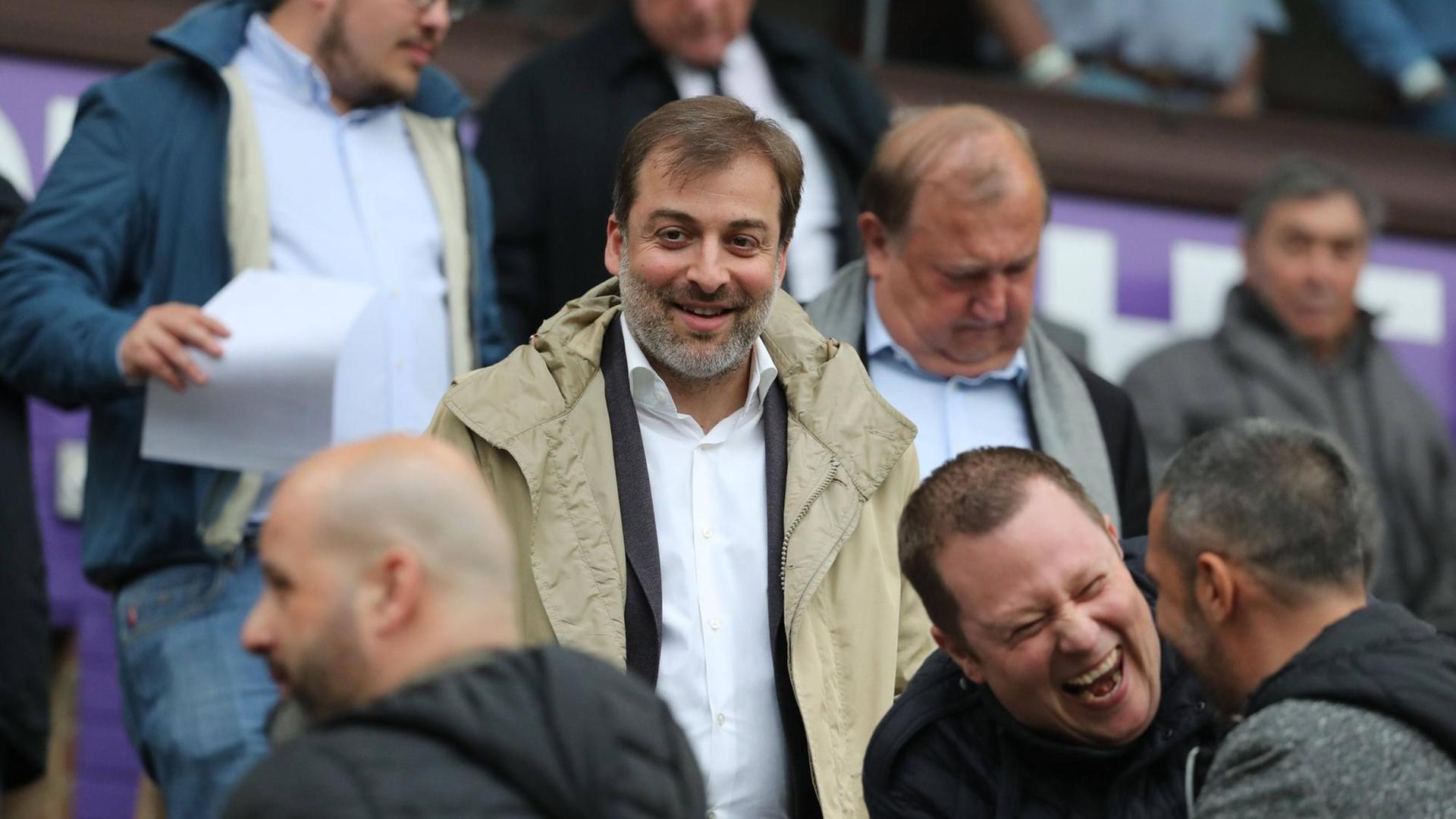 Spieleragent Mogi Bayat steht auf einer Zuschauertribüne und schaut erfreut in die Menge Spieleragent Mogi Bayat steht auf einer Zuschauertribüne und schaut erfreut in die Menge