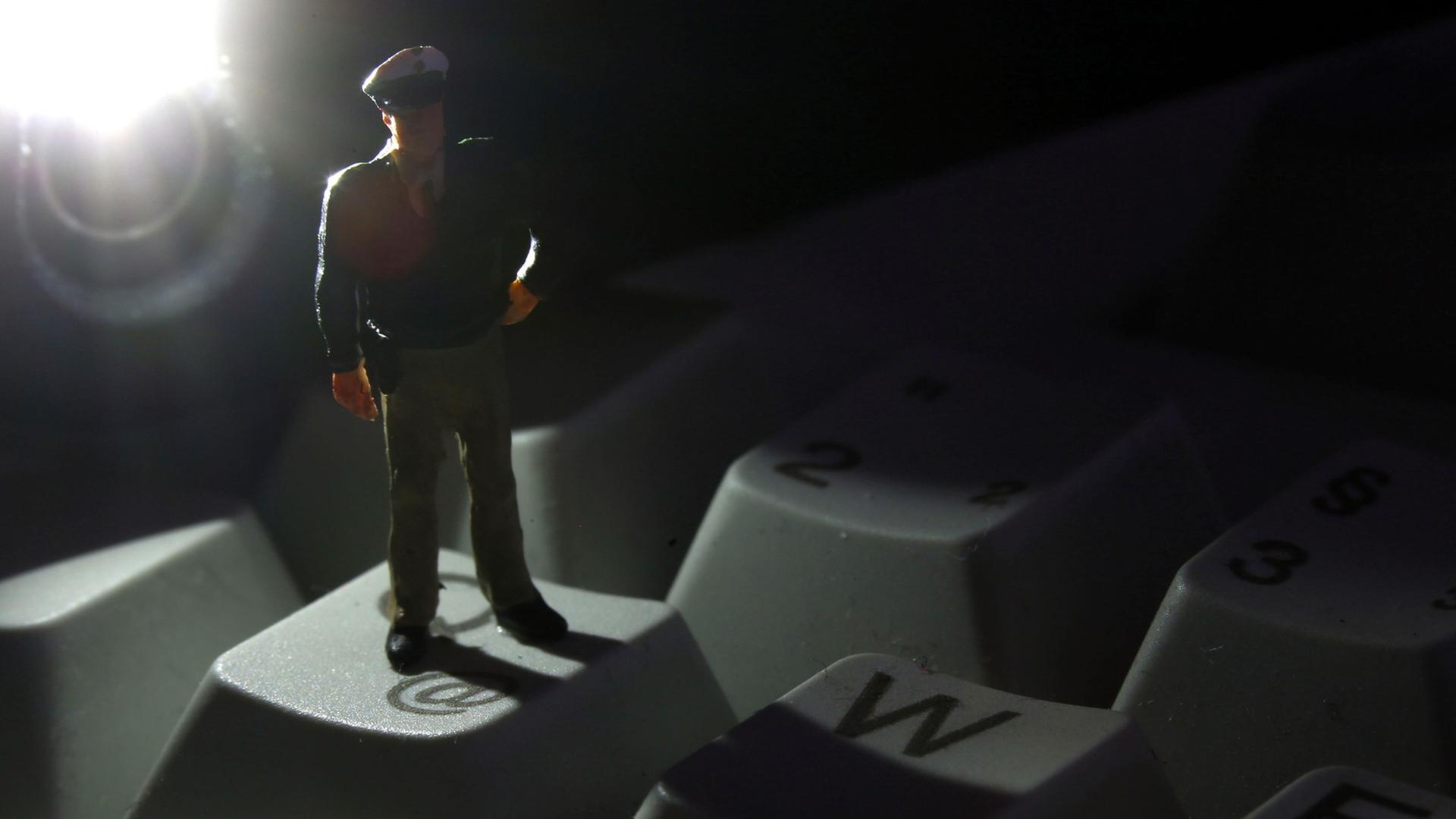 Eine Minifigur eines Polizisten auf der Tastatur eines Rechners Eine Minifigur eines Polizisten auf der Tastatur eines Rechners