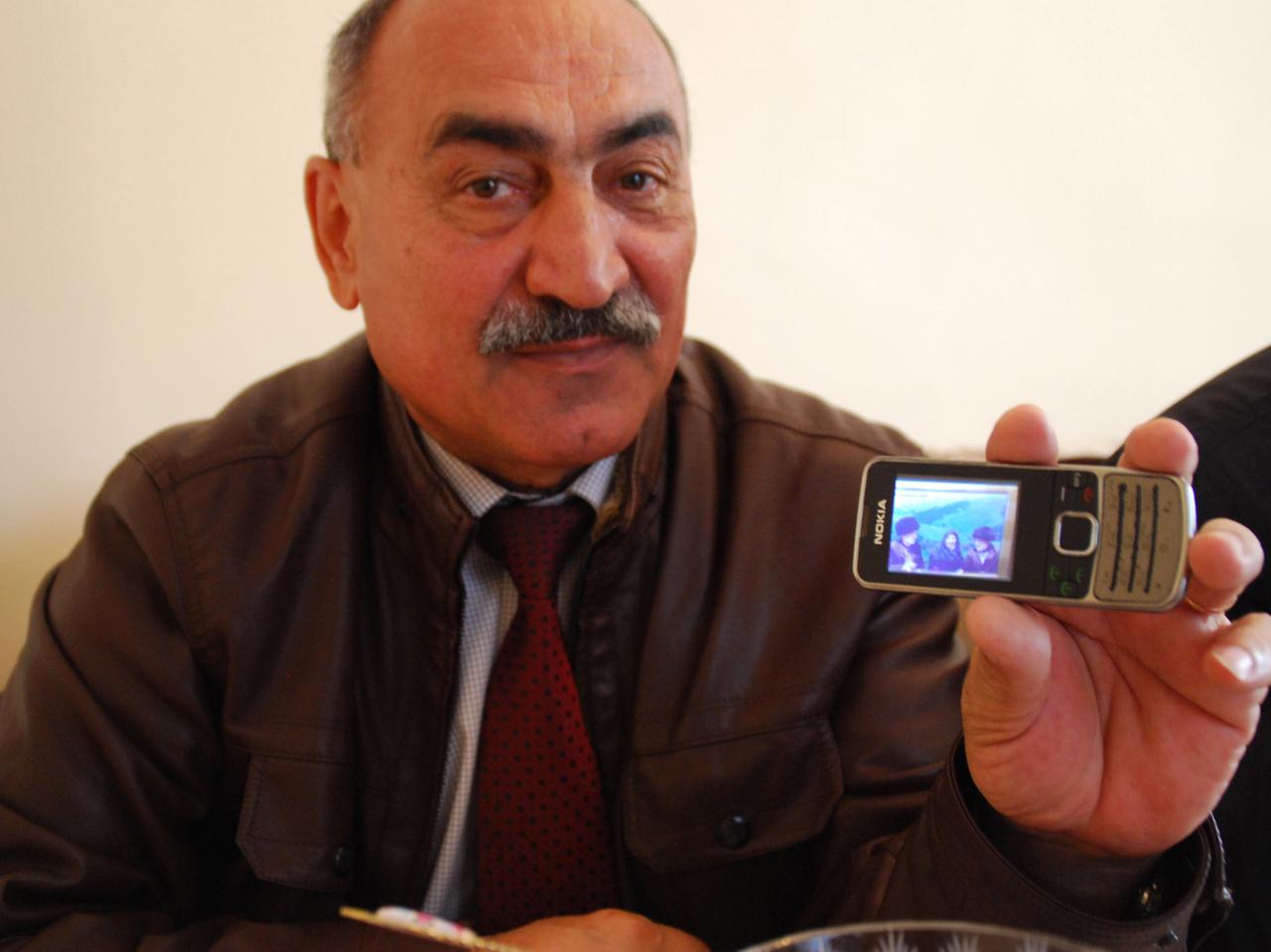 Karabach-Flüchtling Musafer Badaiev zeigt auf seinem Handy ein Bild; es sei das einzige Foto seiner Großeltern, das ihm nach der Vertreibung aus Berg-Karabach 1993 geblieben sei.