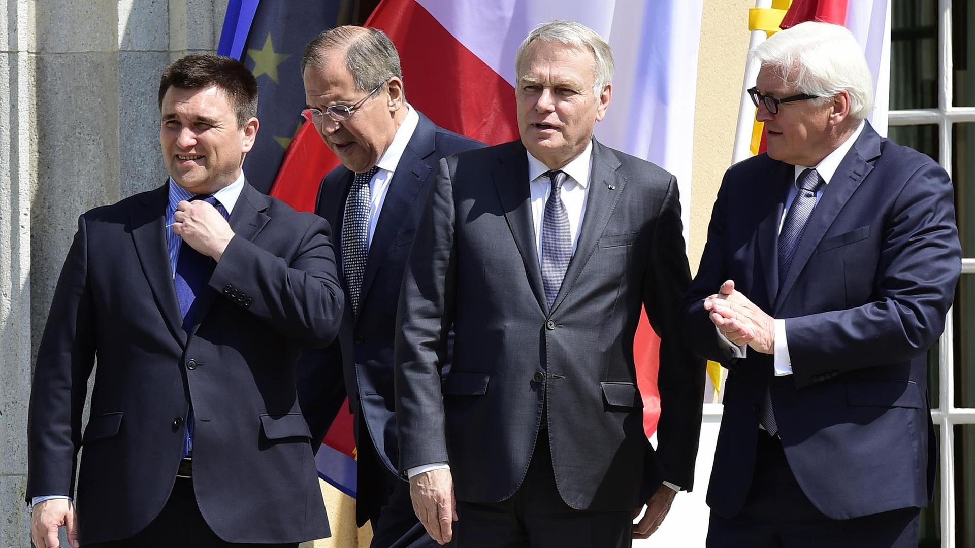 Die Außenminister von Deutschland, Frankreich, Russland und der Ukraine stehen vor der Villa Borsig vor den Flaggen ihrer Länder.