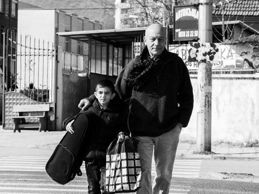 Georgi Kalaidjiev läuft mit einem Schüler seines Projekts "Musik statt Straße" über einen Zebrastreifen