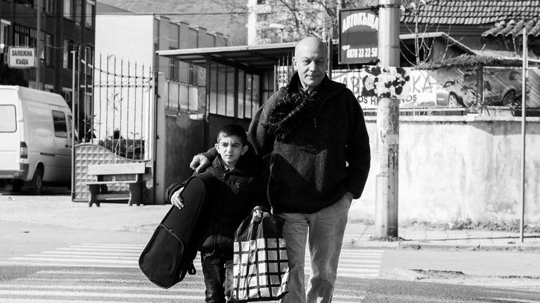 Georgi Kalaidjiev läuft mit einem Schüler seines Projekts "Musik statt Straße" über einen Zebrastreifen Georgi Kalaidjiev läuft mit einem Schüler seines Projekts "Musik statt Straße" über einen Zebrastreifen