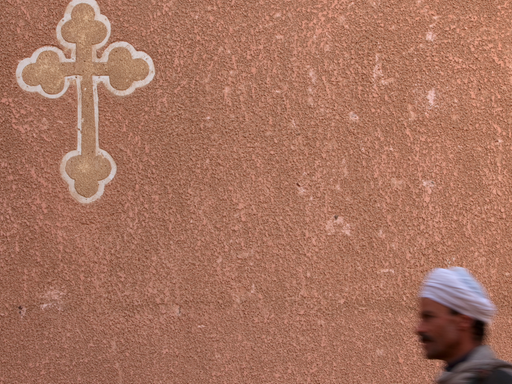 Ein Wächter patrouilliert im Roten Kloster bei Sohag unter dem Kreuz der Kopten (Aufnahme vom 29.1.2010). Christen werden in Ägypten häufig Opfer von Gewalt.