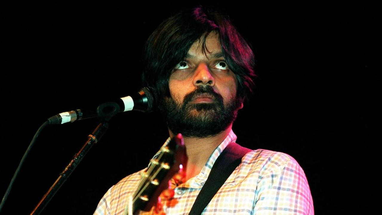 Mann mit Gitarre vor einem Mikrofon Mann mit Gitarre vor einem Mikrofon