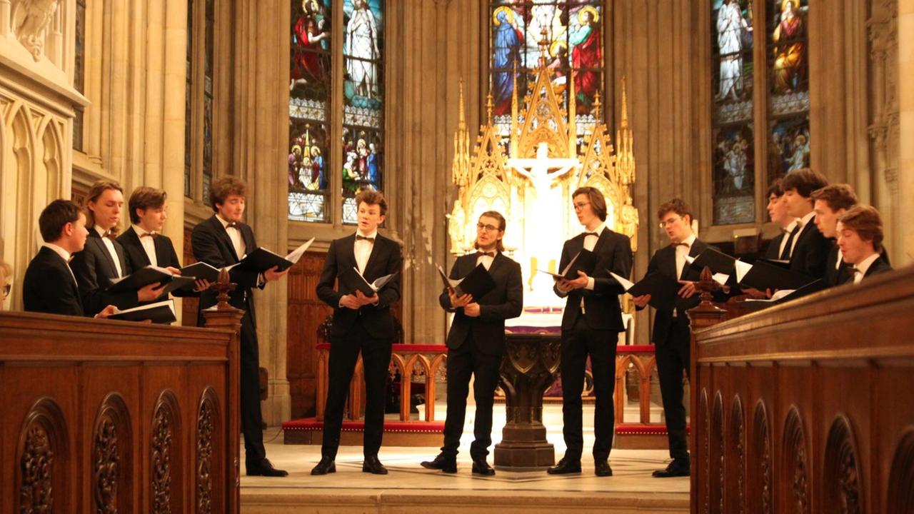 Die jungen Männer der ffortissibros stehen bei einem Auftritt in schwarzen Anzügen im Chorraum einer Kirche.