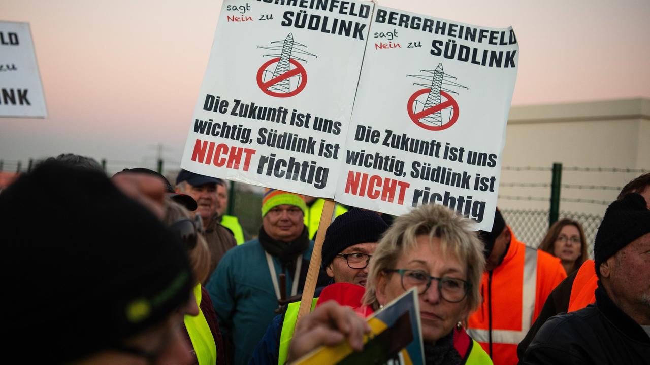 Stromtrassengegner halten vor dem neuen Umspannwerk Schilder mit der Aufschrift "Bergrheinfeld sagt Nein zu Südlink" in die Höhe. Stromtrassengegner halten vor dem neuen Umspannwerk Schilder mit der Aufschrift "Bergrheinfeld sagt Nein zu Südlink" in die Höhe.