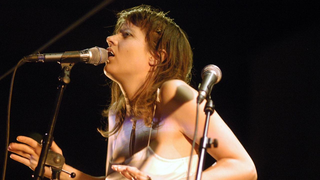 Die Sängerin Camille singt auf einer Bühne am Mikrofon. Die Sängerin Camille singt auf einer Bühne am Mikrofon.