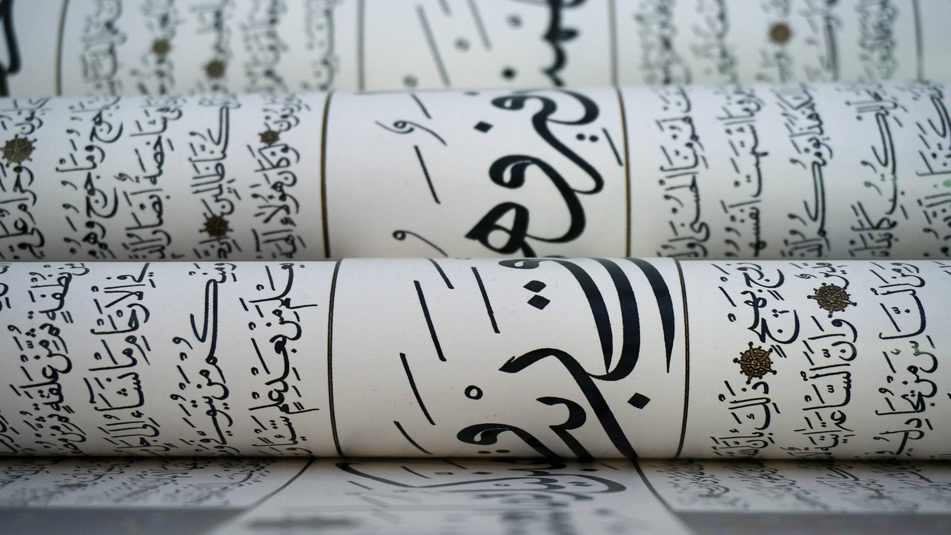 Mehrere Bögen mit arabischer Kalligrafie liegen übereinander.