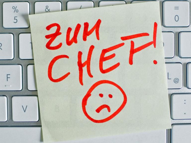 Ein Zettel "Zum Chef!" liegt auf einer Computer-Tatstatur.
