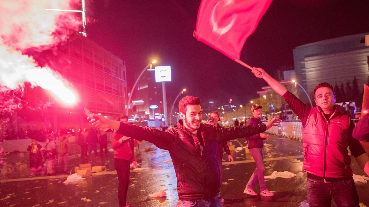 Jubelnde Türken stehen mit Bengalos vor dem Hauptquartier der regierenden AKP in Ankara und feiern die Zustimmung für das Verfassungsreferendum Jubelnde Türken stehen mit Bengalos vor dem Hauptquartier der regierenden AKP in Ankara und feiern die Zustimmung für das Verfassungsreferendum