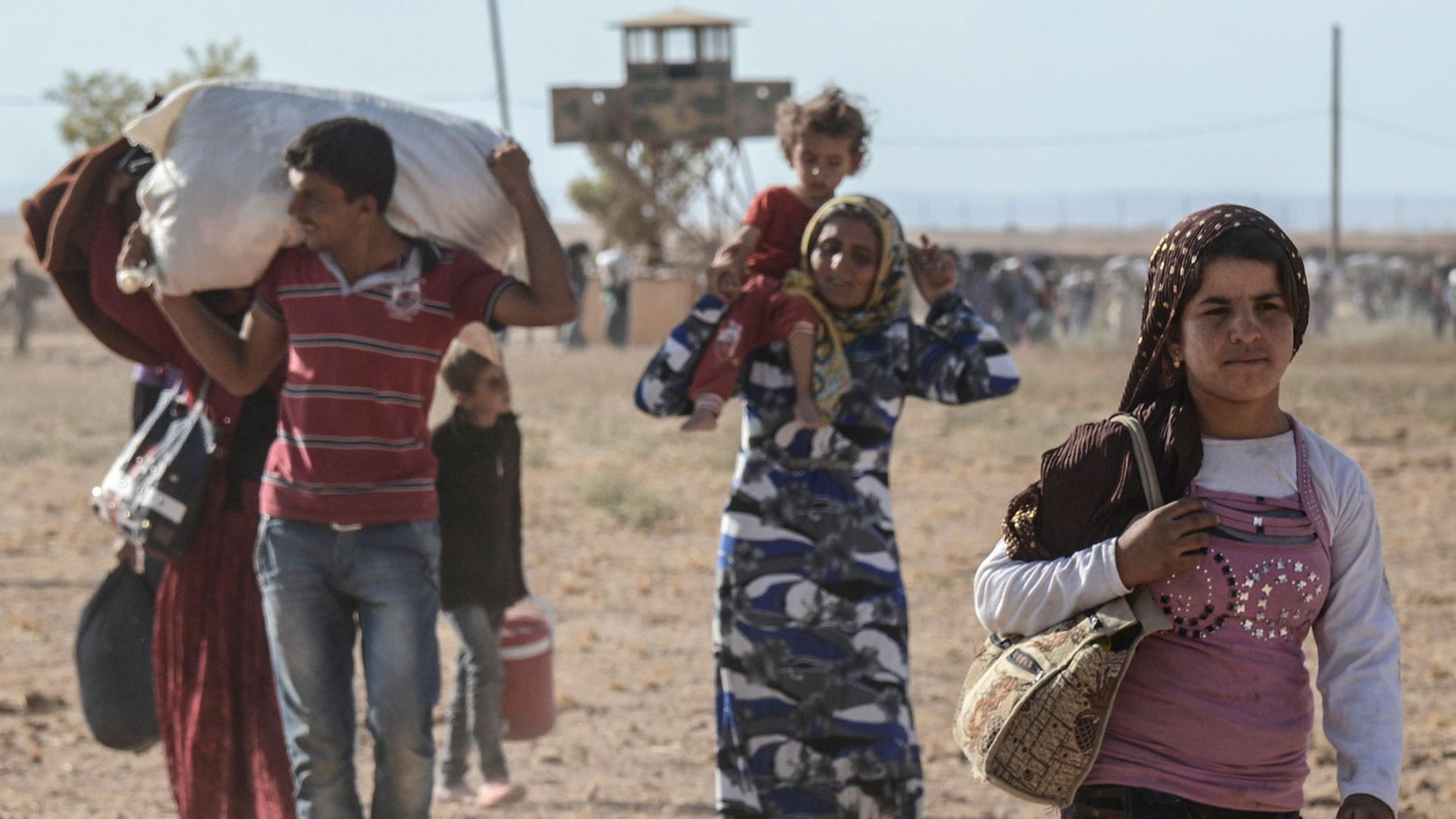 Syrische Kurden überqueren die Grenze zur Türkei. Syrische Kurden überqueren die Grenze zur Türkei.