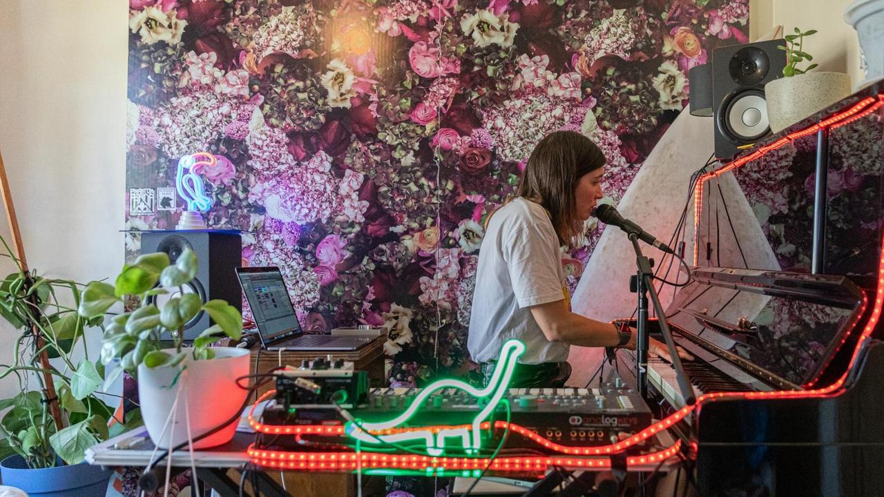 Eine junge Frau sitzt in ihrem Zimmer am Klavier und musiziert. Die Aufführungen werden live auf der Instagram-Seite jedes Künstlers gestreamt. Die Zuschauer können darauf klicken und die Musiker können zwischen den Sets online übergeben. Eine junge Frau sitzt in ihrem Zimmer am Klavier und musiziert. Die Aufführungen werden live auf der Instagram-Seite jedes Künstlers gestreamt. Die Zuschauer können darauf klicken und die Musiker können zwischen den Sets online übergeben.