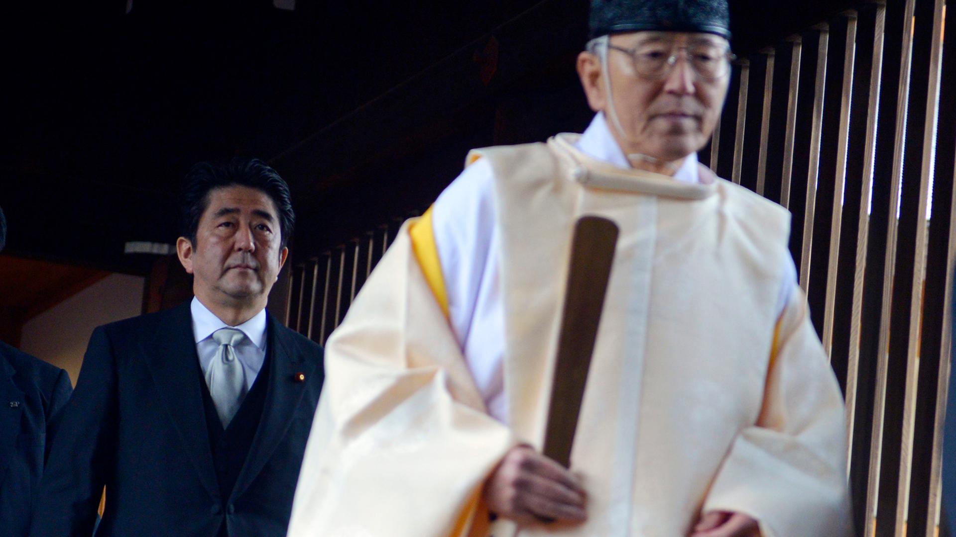 Der japanische Minsterpräsident Shinzo Abe (l.) folgt einem Priester bei seinem Besuch des Yasukuni-Schreins in Tokio am 26. Dezember 2013 Der japanische Minsterpräsident Shinzo Abe (l.) folgt einem Priester bei seinem Besuch des Yasukuni-Schreins in Tokio am 26. Dezember 2013