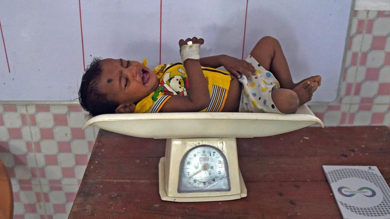 Ein Baby wird in Indien gewogen, um zu prüfen, ob es unterernährt ist. Ein Baby wird in Indien gewogen, um zu prüfen, ob es unterernährt ist.