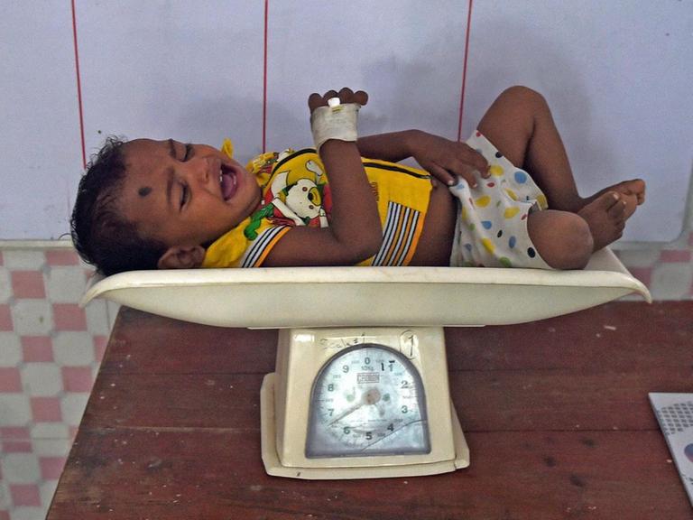 Ein Baby wird in Indien gewogen, um zu prüfen, ob es unterernährt ist.