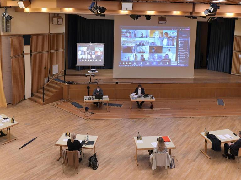 Der Stadtrat von Bad Wörishofen trifft sich zu einer Sitzung im Kurhaus, Die Sitzung wird als "Hybrid-Veranstaltung" wegen der noch hohen Corona-Inzidenz abgehalten. Dazu sind ein paar ausgewählte Mitglieder und der Bürgermeister persönlich anwesend, der Rest wird per Online-Konferenz auf der Videoleinwand zugeschaltet