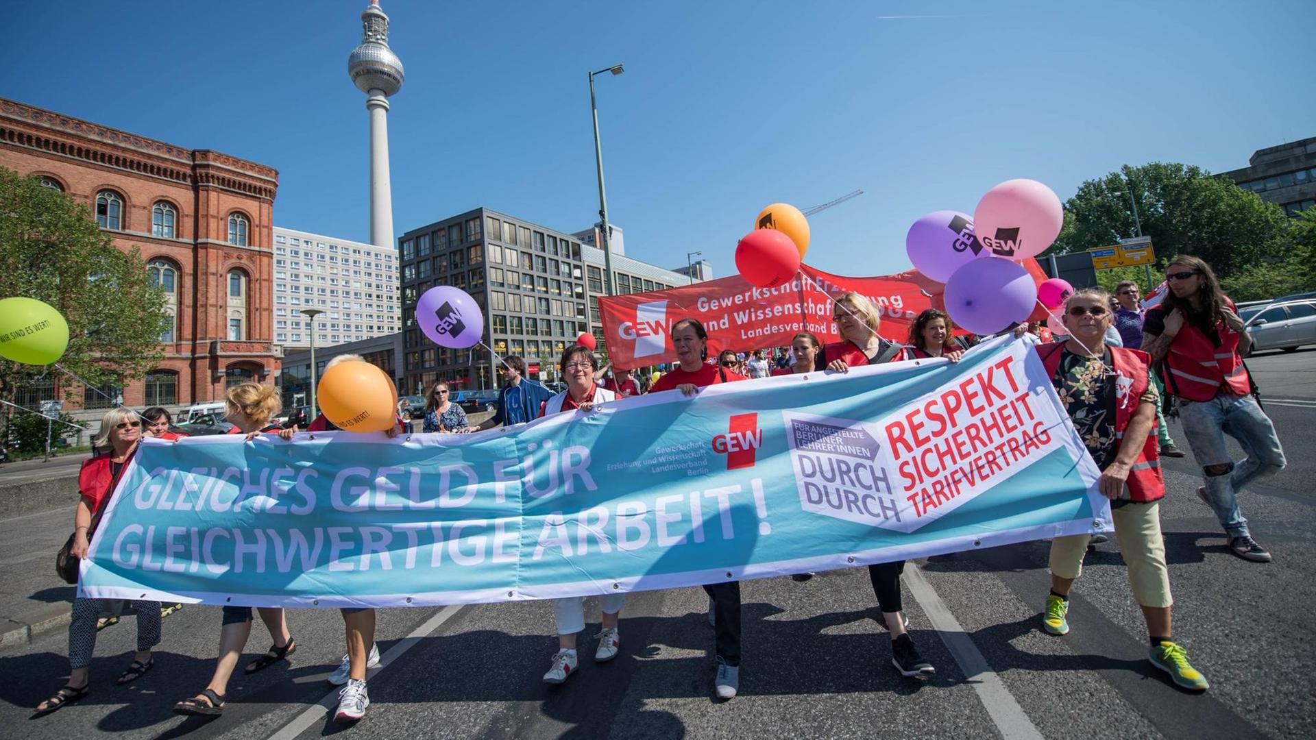 Streikende Lehrinnen und Lehrer halten ein Transparent mit der Aufschrift "Gleiches Gelt für gleichwertige ArbeitW in den Händen. Streikende Lehrinnen und Lehrer halten ein Transparent mit der Aufschrift "Gleiches Gelt für gleichwertige ArbeitW in den Händen.