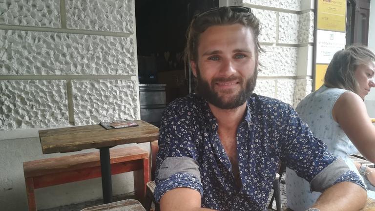 Zu sehen ist ein junger Mann mit Bart an einem Tisch: Gideon Bellin aus Berlin. Zu sehen ist ein junger Mann mit Bart an einem Tisch: Gideon Bellin aus Berlin.