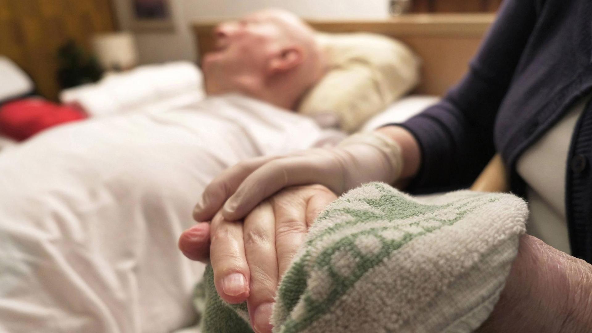 Einblicke in die häusliche Pflege von Angehörigen in der eigenen Familie bei einer Demenzerkrankung. Ein Frau wäscht mit einem Lappen die Hand von einem älteren Mann. Einblicke in die häusliche Pflege von Angehörigen in der eigenen Familie bei einer Demenzerkrankung. Ein Frau wäscht mit einem Lappen die Hand von einem älteren Mann.