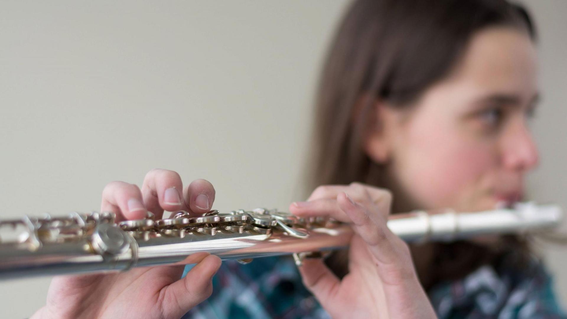 Ein Teenager spielt Querflöte. Ein Teenager spielt Querflöte.