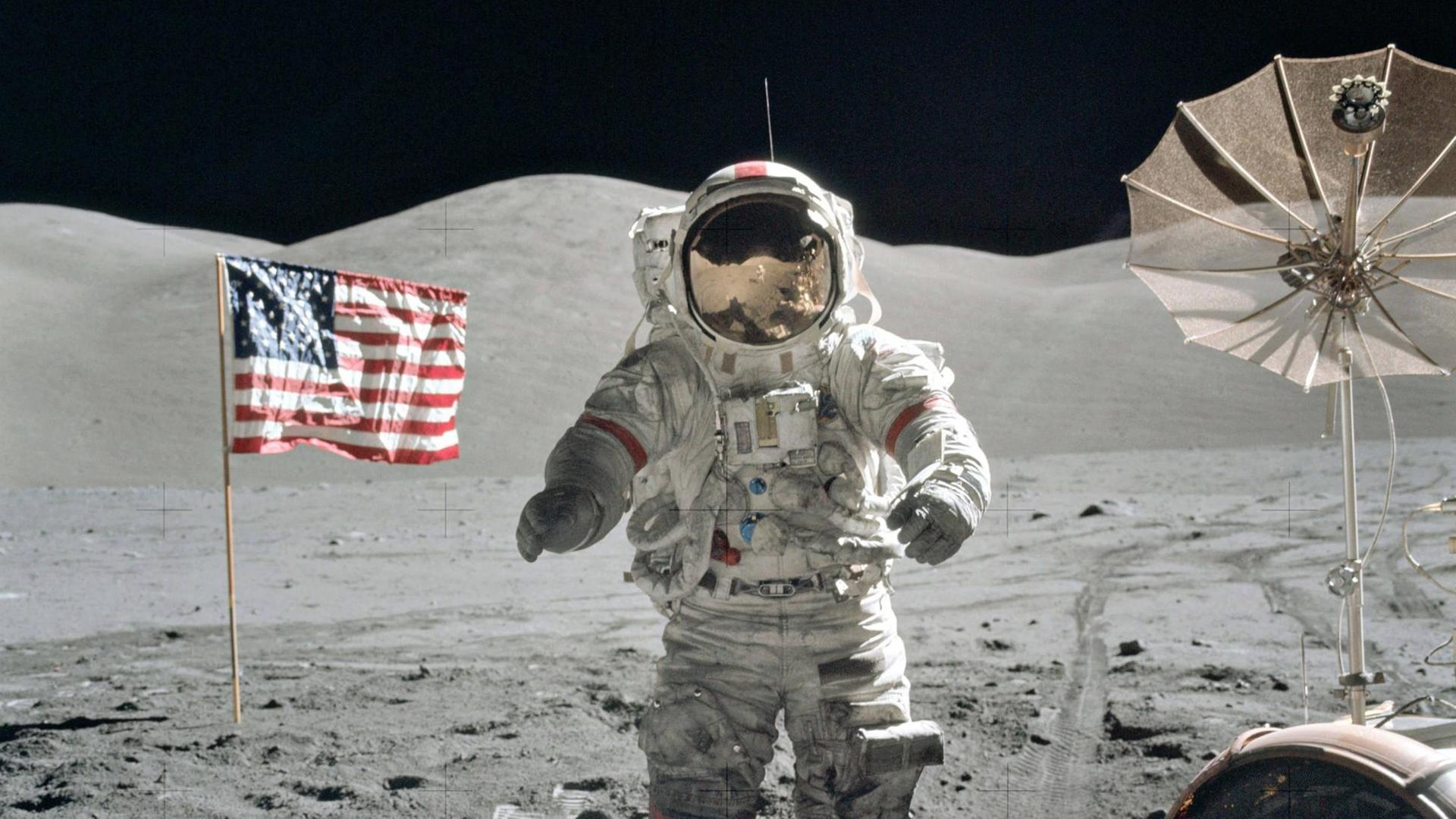 Der US-amerikanische NASA-Astronaut Eugene Cernan, Kommandant der Apollo 17, spaziert am 13. Dezember 1972 auf dem Mond herum. Im Hintergrund ist die US-Flagge zu sehen und eine Antenne. Der US-amerikanische NASA-Astronaut Eugene Cernan, Kommandant der Apollo 17, spaziert am 13. Dezember 1972 auf dem Mond herum. Im Hintergrund ist die US-Flagge zu sehen und eine Antenne.