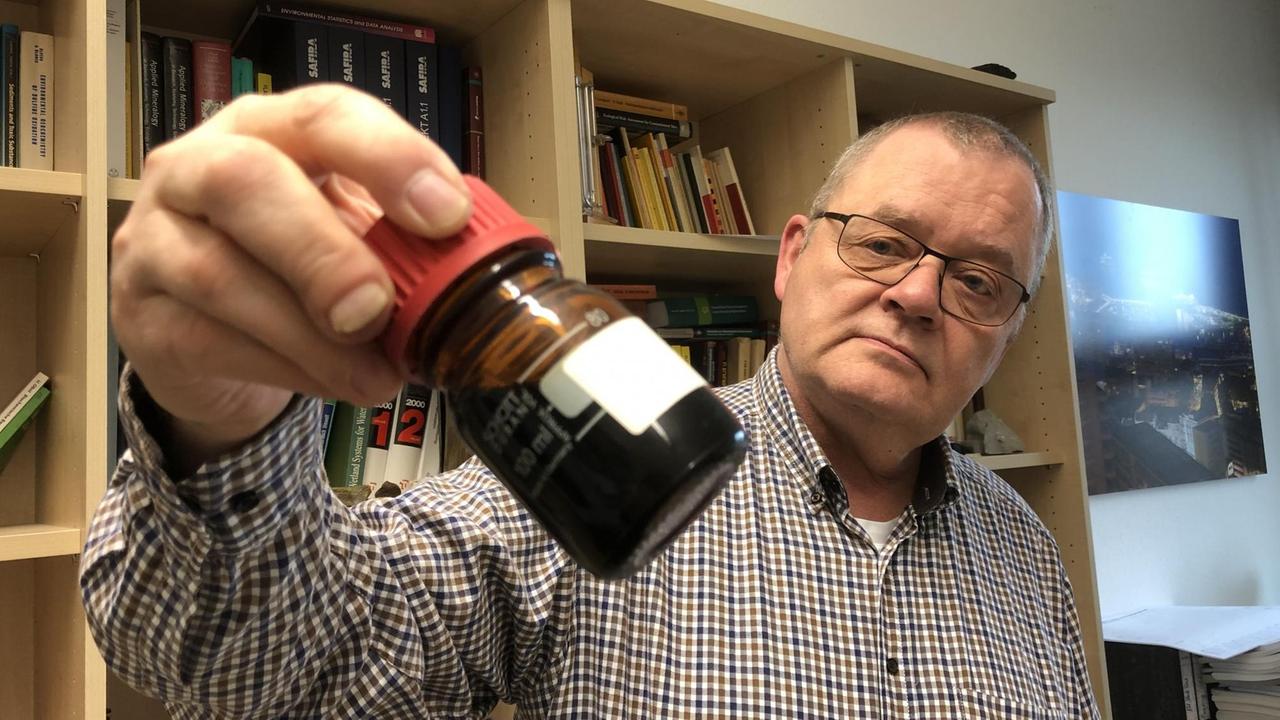 Holger Weiß, Grundwasserexperte Helmholtz-Institut Leipzig, hält eine Flasche mit Bitterfelder Grundwasser in der Hand Holger Weiß, Grundwasserexperte Helmholtz-Institut Leipzig, hält eine Flasche mit Bitterfelder Grundwasser in der Hand