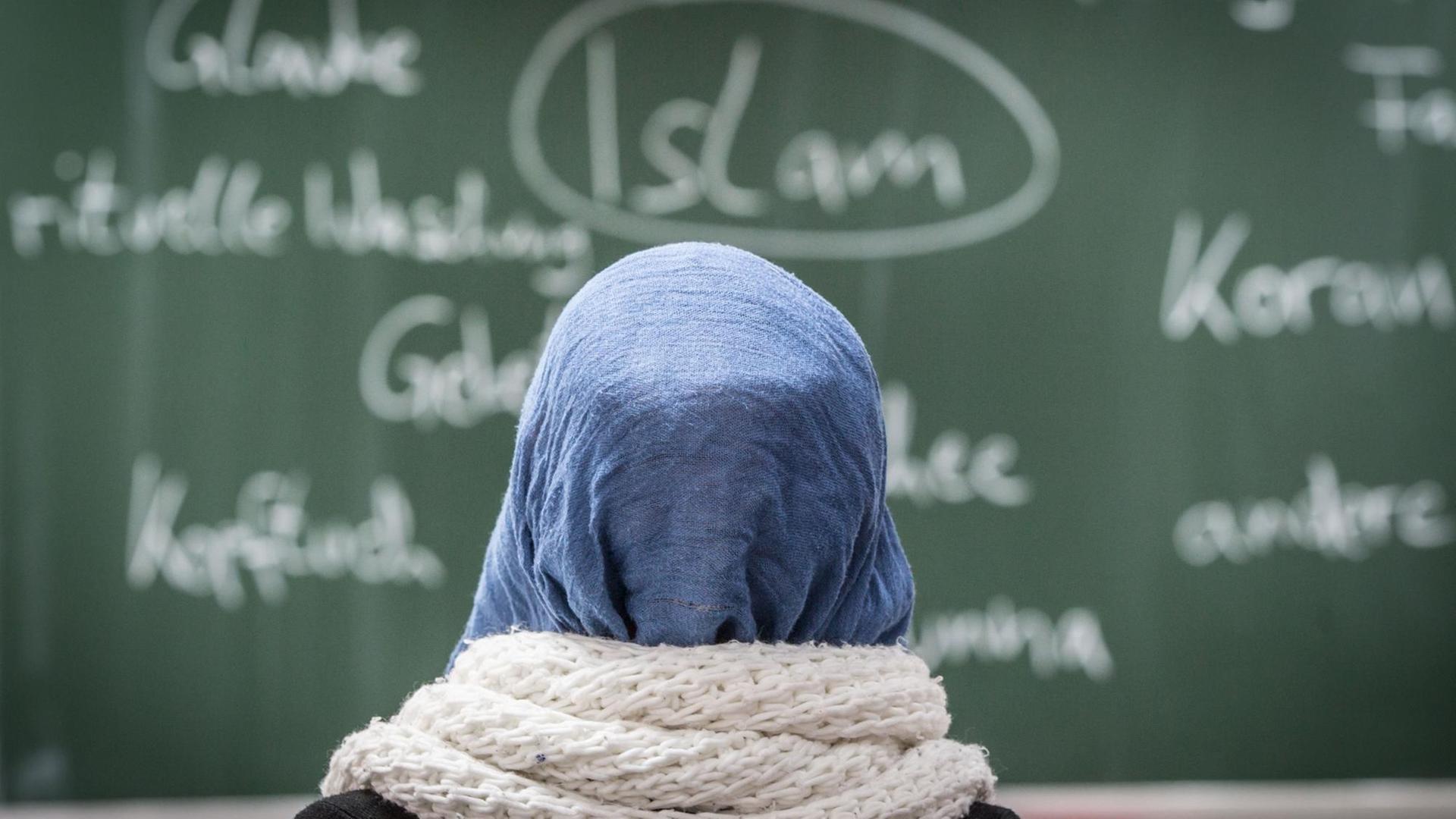 Eine Schülerin mit Kopftuch sitzt bei einer Unterrichtsstunde zum Thema Islam Eine Schülerin mit Kopftuch sitzt bei einer Unterrichtsstunde zum Thema Islam