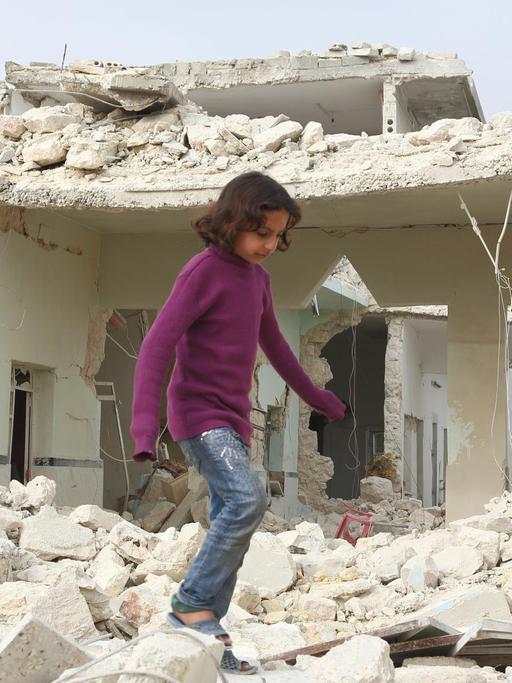 Ein Mädchen läuft im Tareeq Al-bab-Viertel Aleppos durch Trümmer vor Haus, das am Abend zuvor von einem Raketenangriff zerstört wurde. 23. Februar 2013 Foto: Jan A. Nicolas dpa