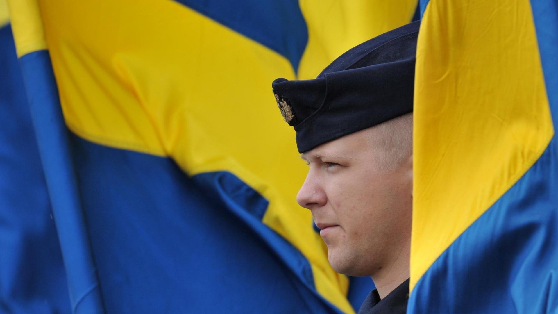 Ein schwedischer Soldat mit schwedischer Flagge