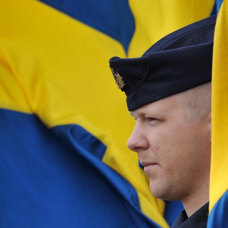  Ein schwedischer Soldat mit schwedischer Flagge