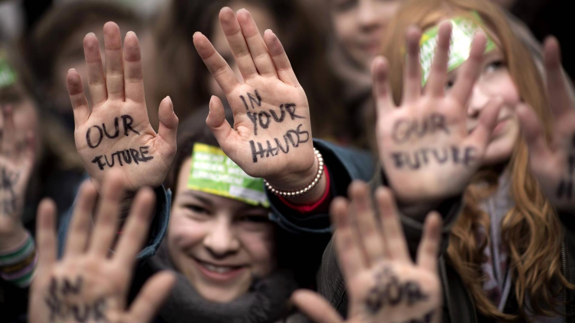 Demonstration der weltweiten "FridaysForFuture"-Bewegung: Schülerinnen halten ihre mit dem Satz "Our Future" und "In Your Hands" beschrifteten Handfläche in die Lust, aufgenommen am 15. März 2019 in Berlin Demonstration der weltweiten "FridaysForFuture"-Bewegung: Schülerinnen halten ihre mit dem Satz "Our Future" und "In Your Hands" beschrifteten Handfläche in die Lust, aufgenommen am 15. März 2019 in Berlin