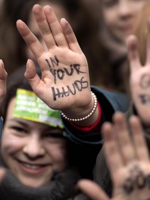 Demonstration der weltweiten "FridaysForFuture"-Bewegung: Schülerinnen halten ihre mit dem Satz "Our Future" und "In Your Hands" beschrifteten Handfläche in die Lust, aufgenommen am 15. März 2019 in Berlin