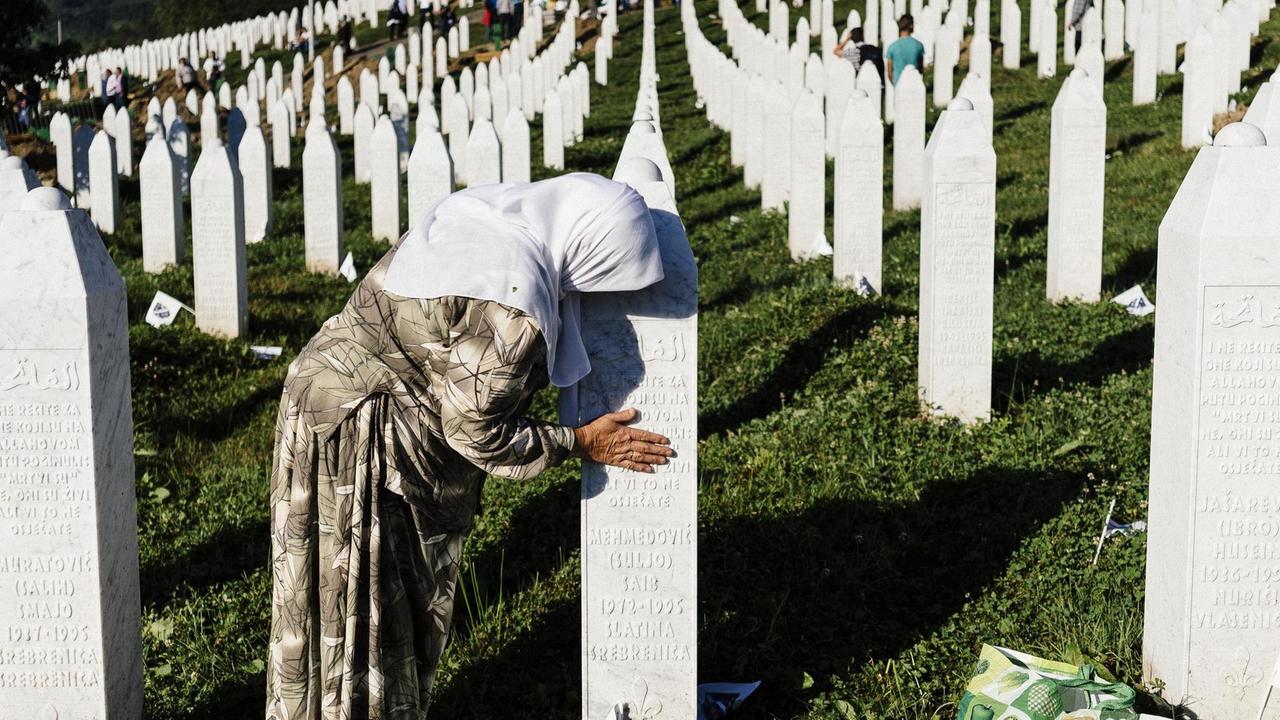 Eine Frau trauer am Grab eines Verwandten in der Nähe von Srebrenica. Eine Frau trauer am Grab eines Verwandten in der Nähe von Srebrenica.
