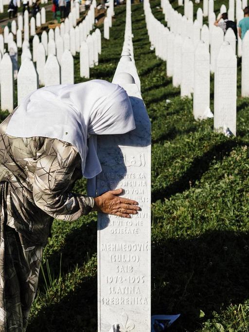 Eine Frau trauer am Grab eines Verwandten in der Nähe von Srebrenica.