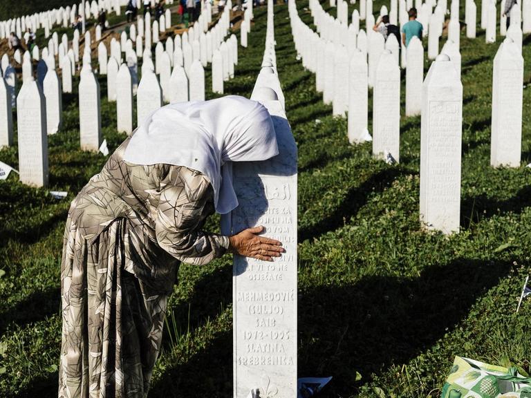 Eine Frau trauer am Grab eines Verwandten in der Nähe von Srebrenica.