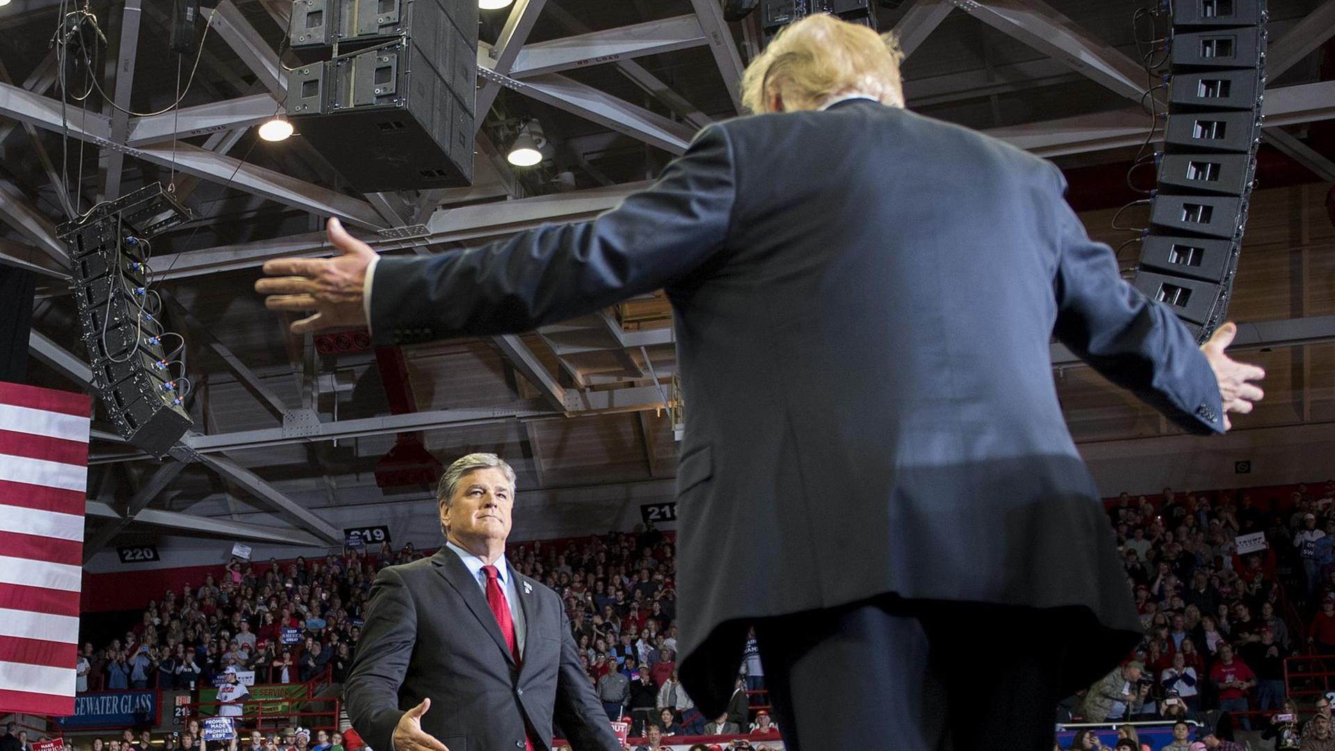 US President Donald Trump greets talk show host Sean Hannity at a Make America Great Again rally in Cape Girardeau, Missouri on November 5, 2018. (Photo by Jim WATSON / AFP)