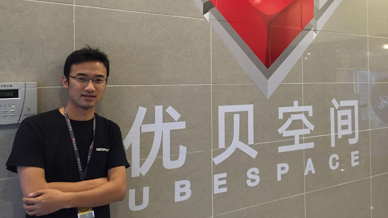 Wang Yujia steht vor einer Wand mit einem Logo Wang Yujia steht vor einer Wand mit einem Logo