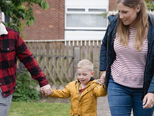 Vater und Mutter mit ihrem kleinen Sohn an der Hand