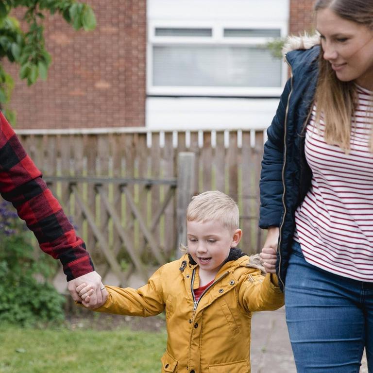Vater und Mutter mit ihrem kleinen Sohn an der Hand