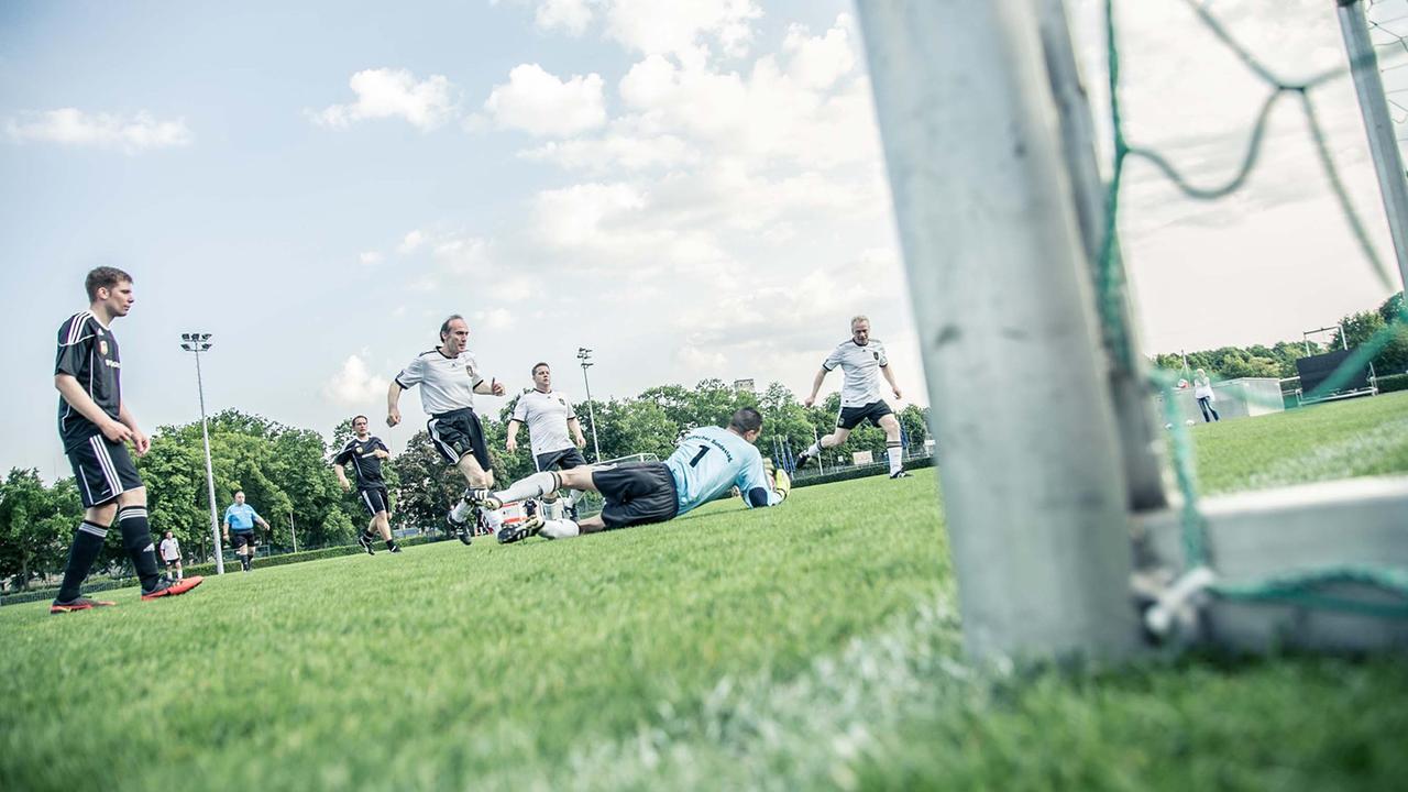 Spieler des FC Bundestag und einer gegnerischen Mannschaft stehen auf dem Rasen vor einem Tor