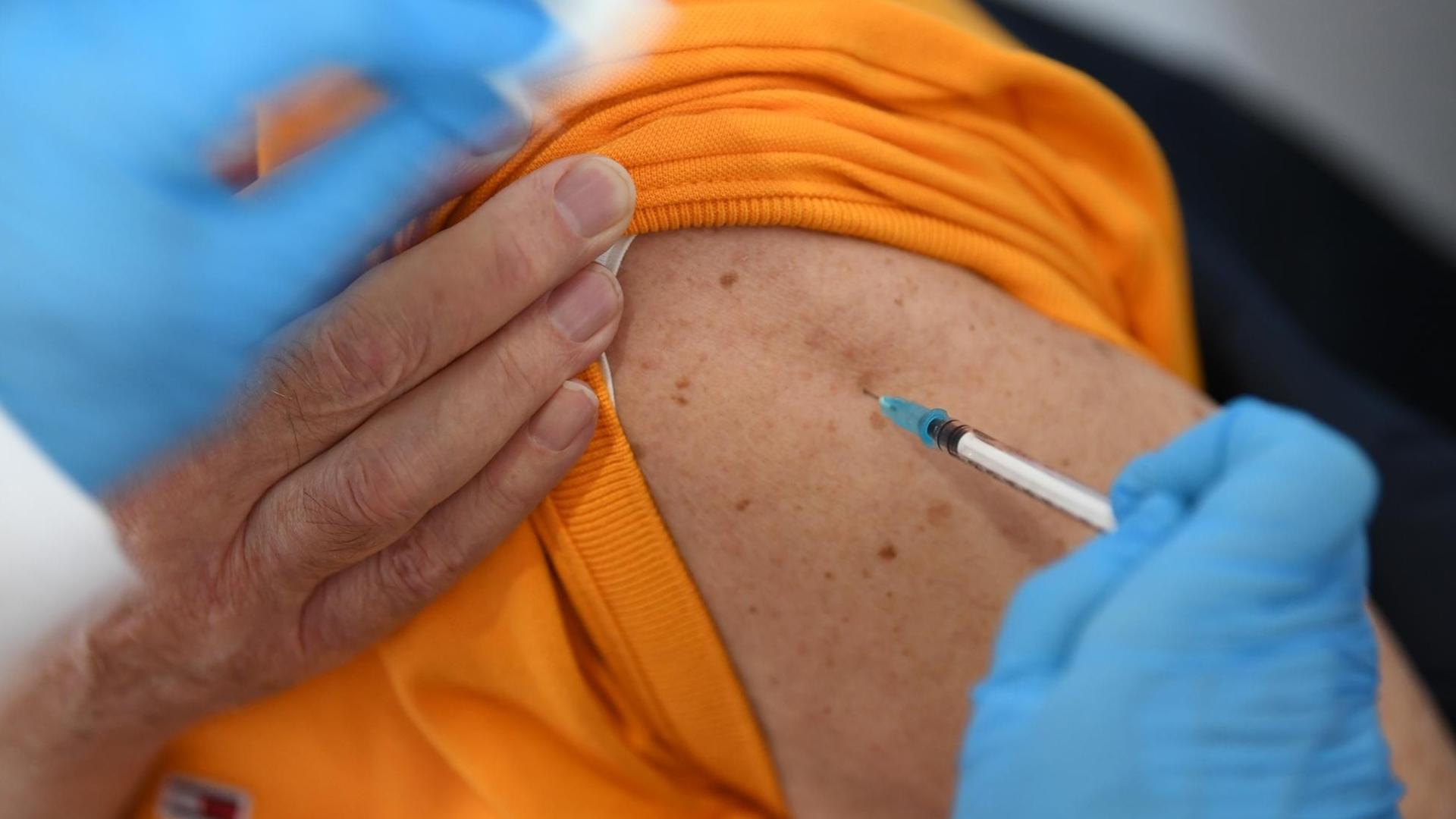 Ein Senior wird von einer medizinischen Fachkraft mit dem Pfizer-BioNTech-COVID-19-Impfstoff geimpft. Am Mittag hatte das Kreisimpfzentrum in der Messe Friedrichshafen aufgemacht.